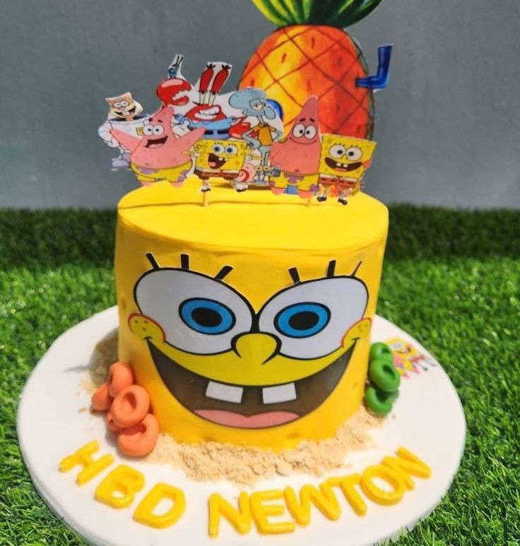SpongeBob-themed birthday cake with cartoon characters and pineapple decoration.
